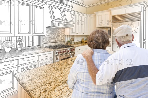 Senior couple looking over custom kitchen design drawing and photo combination