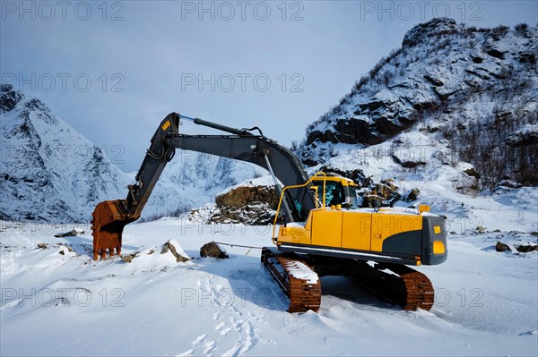 Old excavator with excavator bucket in winter