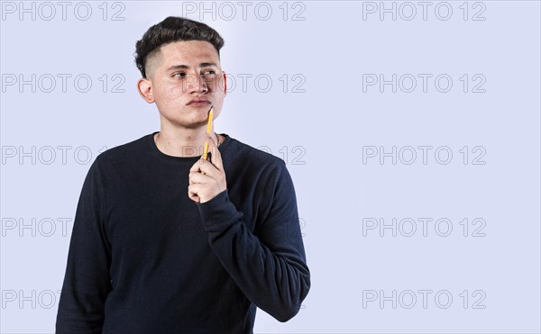 Young man wondering with his hand on his chin on an isolated background