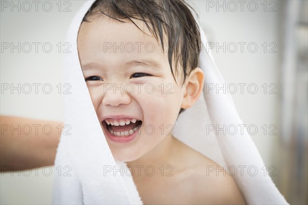 mixed-race boy having fun at the water park with white towel on his head