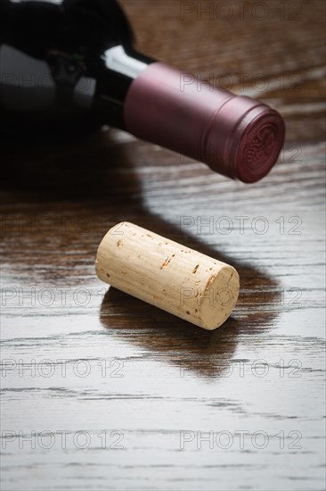 Wine bottle and cork on a reflective wood surface abstract