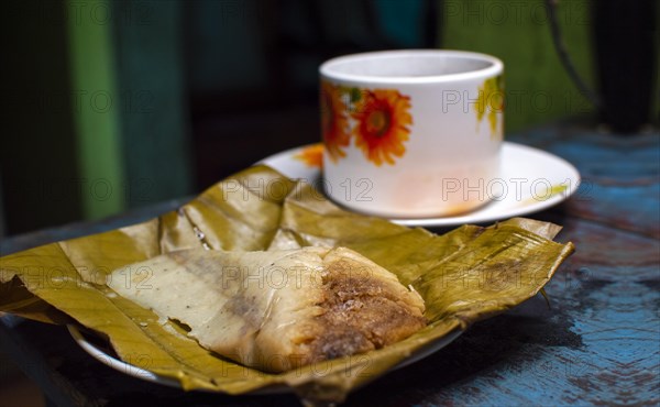 Stuffed tamale served on wooden table