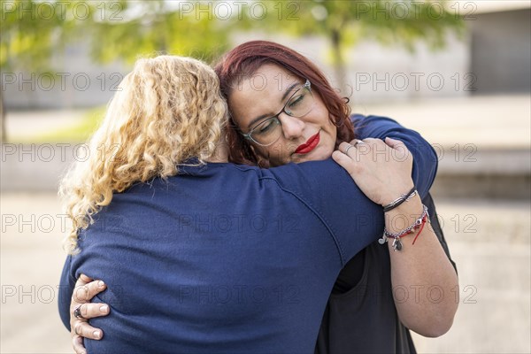 Couple of lesbian women hugging in a park