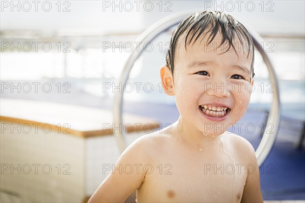 mixed-race boy having fun at the water park with large rubber duck in the background