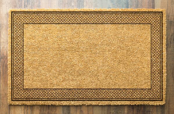 Blank welcome mat on wood floor background ready for your own text