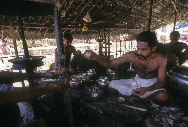 Priest giving prasad to the devotees in Kottiyur Siva temple festival near Thalassery