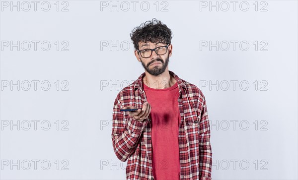 Skeptical man with cell phone in hand