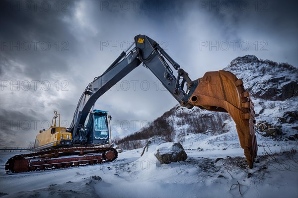 Old excavator with excavator bucket in winter