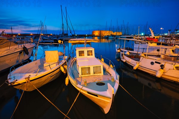 Venetian Fort castle in Heraklion and moored Greek fishing boats in port