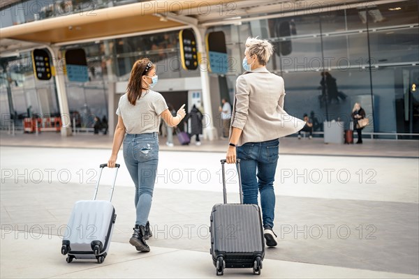 Female friends with luggage approaching the airport ready for the trip