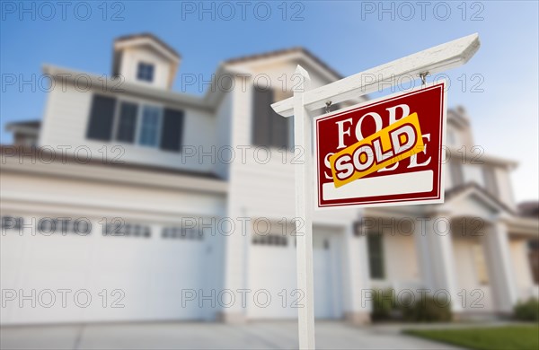 Sold home for sale real estate sign in front of beautiful new house