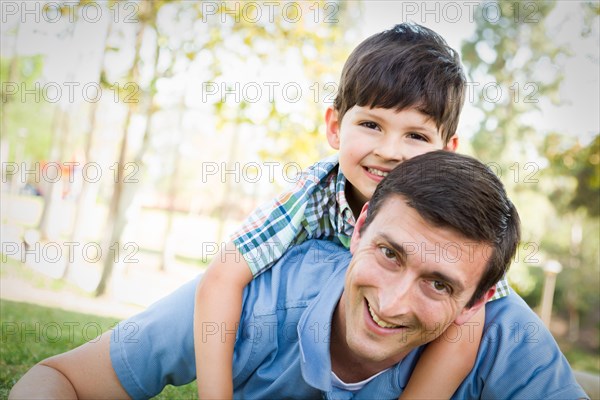 mixed-race father and son playing together in the park