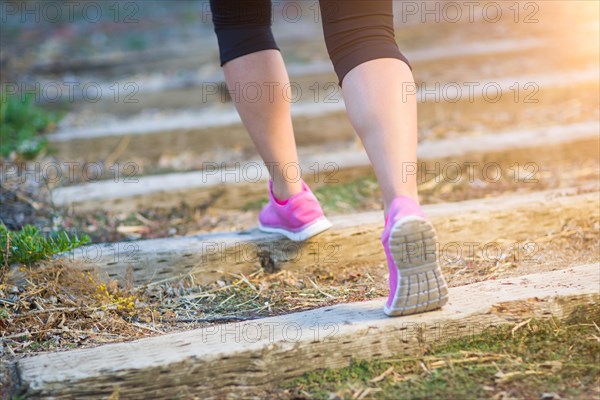Young fit adult woman outdoors walking or running up wooden steps