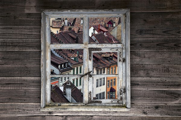 View through a rustic wooden window onto the old town