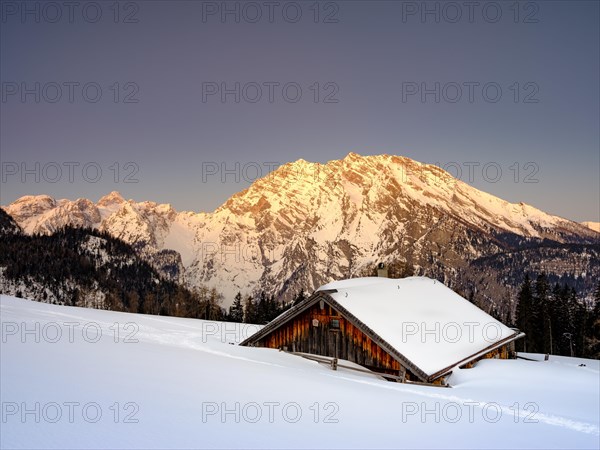 Snowy Priesbergalm in front of Watzmann east face at sunrise