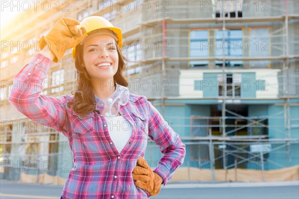 Portrait of young female construction worker wearing gloves