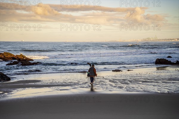 A fisherman walking on Samoqueira Beach