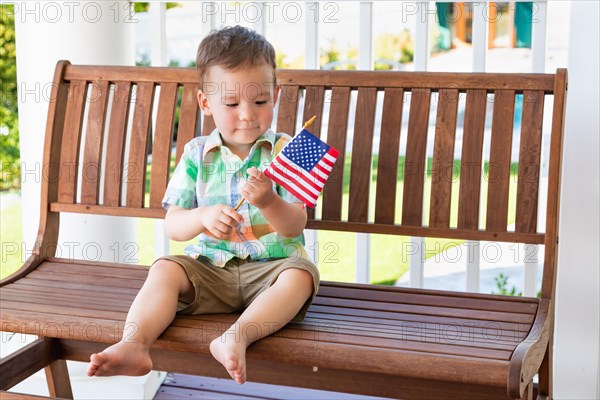 Young mixed-race chinese and caucasian boy playing with american flag