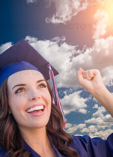 Happy graduating mixed-race woman in cap and gown