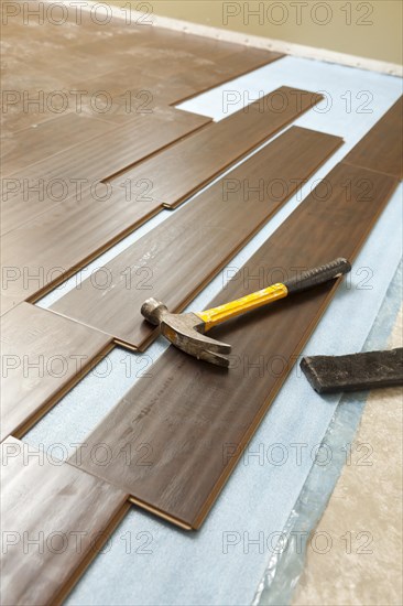 Hammer and block with new laminate flooring abstract