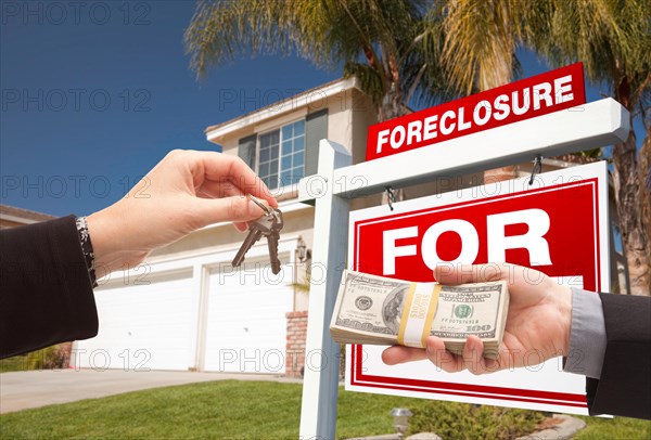 Handing over cash for house keys in front of house and foreclosure sign
