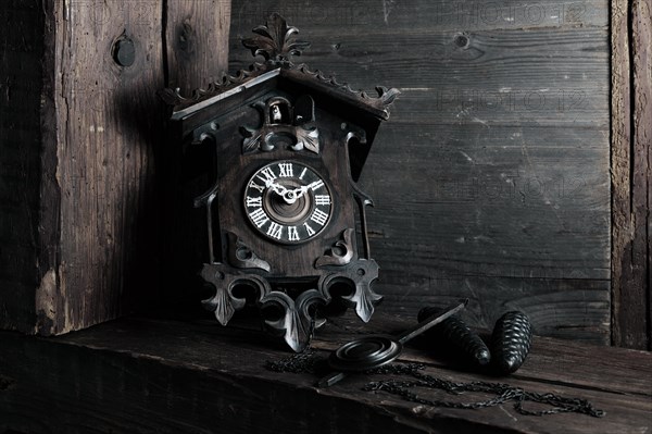 Antique Black Forest cuckoo clock on wooden background