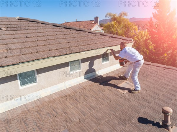 Professional painter using A brush to paint house facade