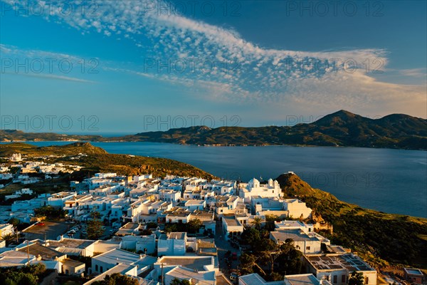 View of Plaka village on Milos island with traditional greek white houses on sunset. Plaka town