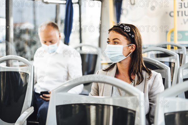 Travelers wearing protective masks commuting by public bus