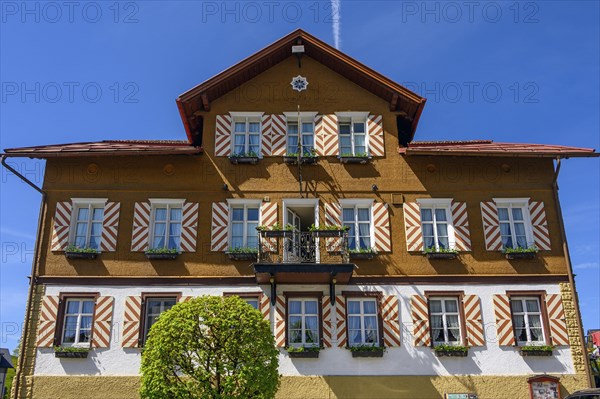 Wooden shingle facade with striped shutters