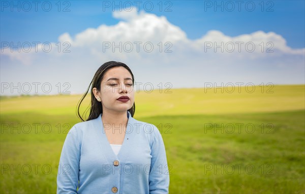 A young girl breathing fresh air in the field