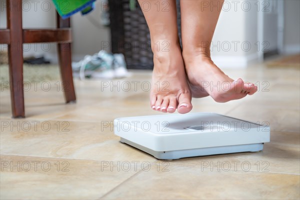 Woman floating slightly above surface of weight scale