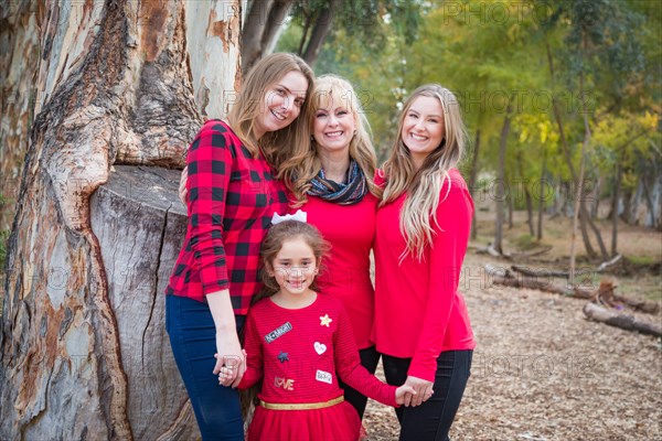 Beautiful mother with young adult daughters and mixed-race granddaughter portrait outdoors