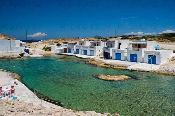 The beach of Agios Konstantinos with crystal clear turquoise water and traditional greek white houses. Milos island