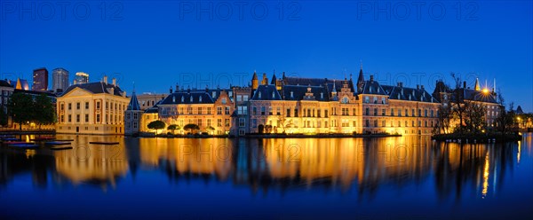 Panorama of the Binnenhof House of Parliament and Mauritshuis museum and the Hofvijver lake illuminated in the night. The Hague