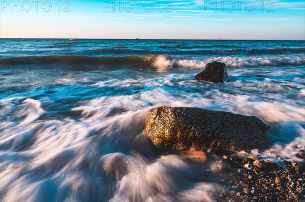 Langzeitbelichtung von einem Fels in der Brandung der Ostsee bei starkem Wellengang