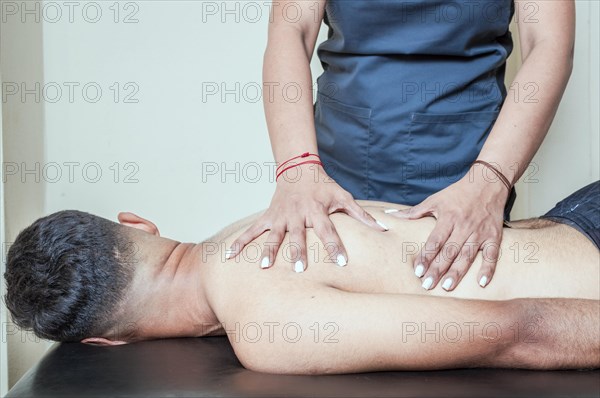 Man having chiropractic back adjustment. physiotherapist curing patient's spine problems