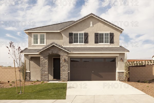 A newly constructed modern home facade and yard