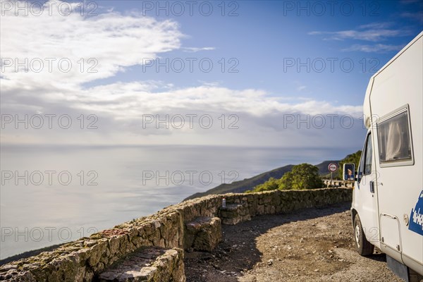 Small camper van parked on the side of the road in Arrabida Natural Park