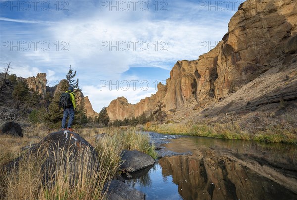 Young man standing on stone on the shore