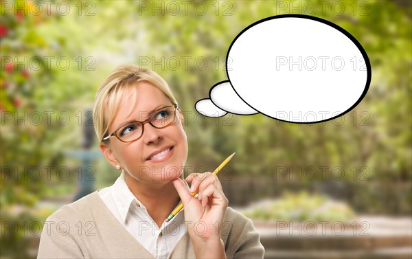 Thoughtful young woman with pencil and blank thought bubble