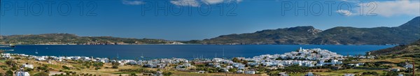 Panorama of Plaka village with traditional Greek church white painted Greek houses and ocean coast. Milos island