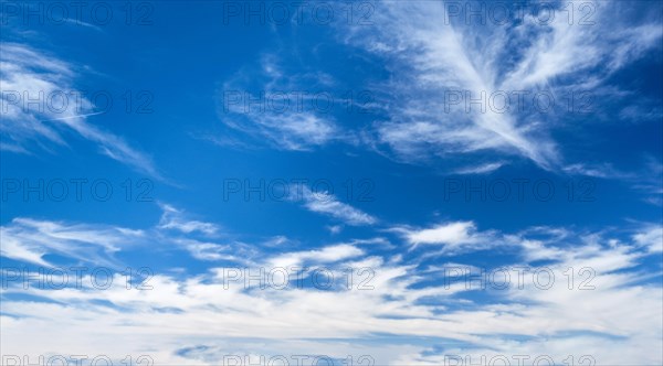 Blue clear sky with white cirrus spindrift clouds background