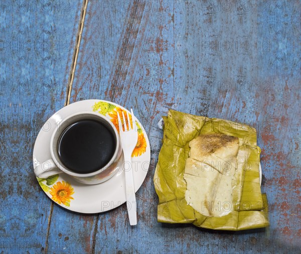 Stuffed tamale served on wooden table