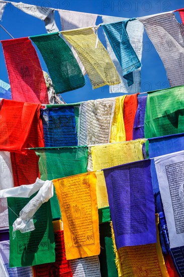 Buddhist prayer flags lungta with Om Mani Padme Hum Buddhist mantra prayer meaning Praise to the Jewel in the Lotus on kora around Tsuglagkhang complex. McLeod Ganj