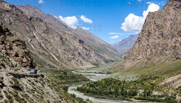 Manali-Leh road in Indian Himalayas with lorry and Chandra river in Lahaul valley. Himachal Pradesh