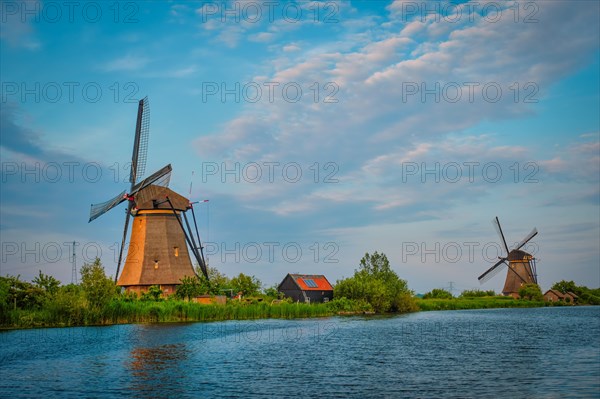 Netherlands rural landscape with windmills at famous tourist site Kinderdijk in Holland on sunset with dramatic sky
