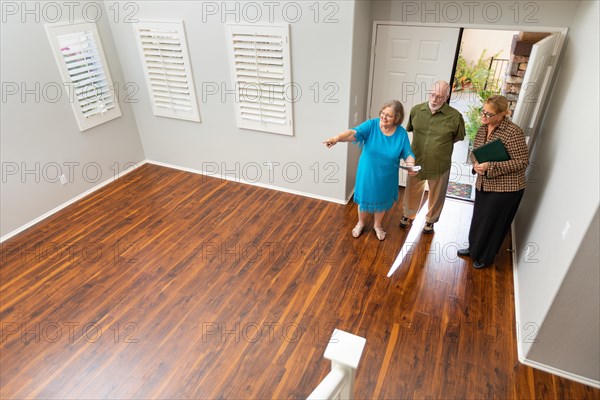 Female real estate agent showing senior adult couple A new home