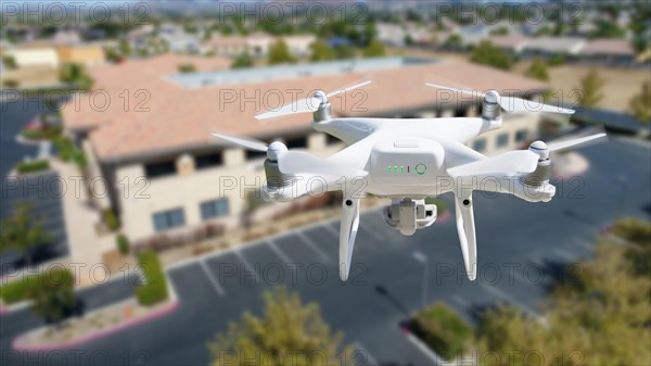 Unmanned aircraft system quadcopter drone in the air near corporate industrial building