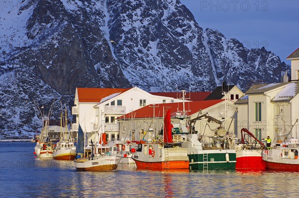 Small fishing boats in front of wooden houses in winter evening light